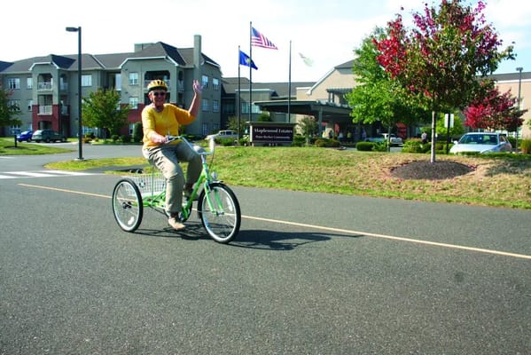 A resident riding a tricycle in front of the facility