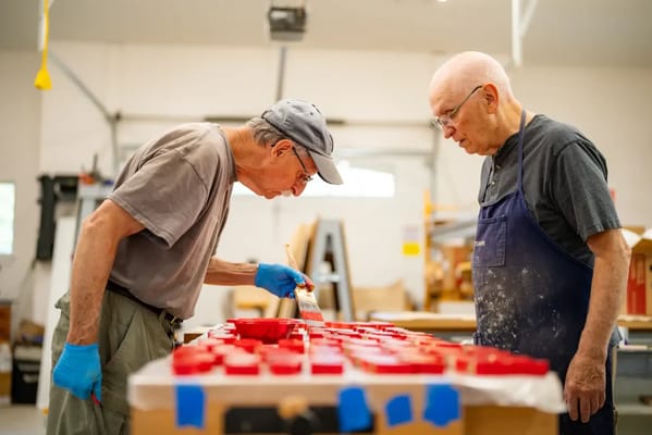 Two senior men working on a craft project indoors