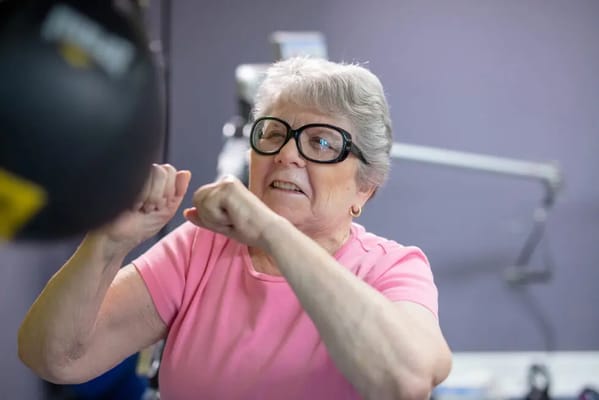 Senior woman exercising with a punching bag