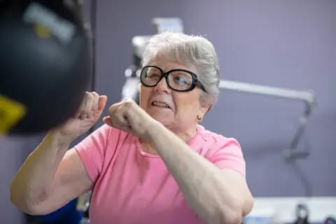 Senior woman practicing boxing drills in a fitness area