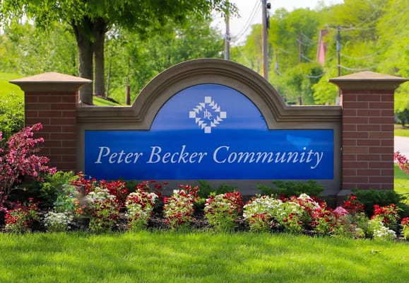 Signage for Peter Becker Community surrounded by flowers