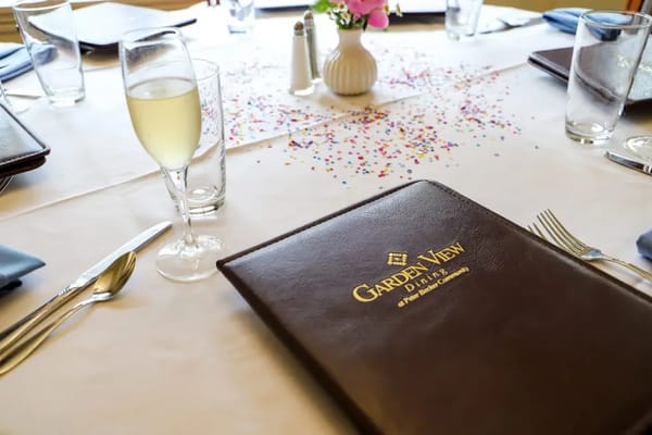 Table setting in a dining room with a menu and drinks.