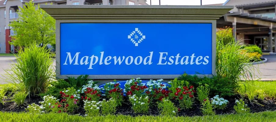 Sign for Maplewood Estates with flowers and greenery