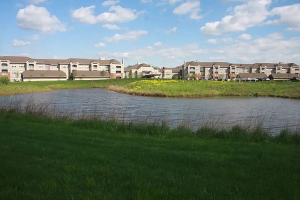 View of the facility beside a pond and grass area