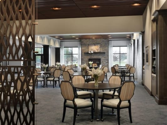 Bright dining room with tables and chairs surrounded by windows