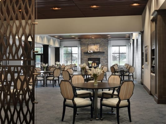 Bright dining room with tables and chairs surrounded by windows