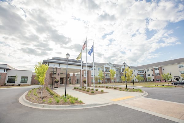 Front entrance of a senior living facility with flags