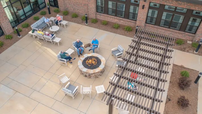 Residents socializing around a central fire pit in the courtyard