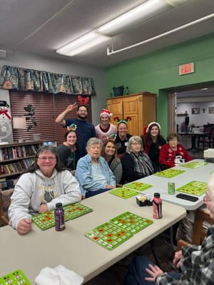 Residents and staff enjoying bingo together in a festive setting