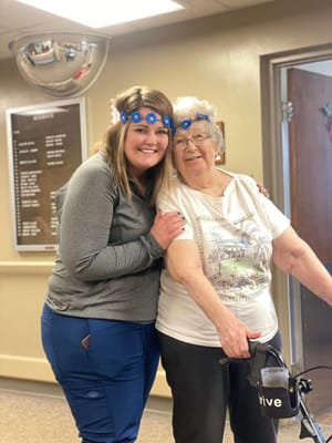 Resident and staff member posing together in common area