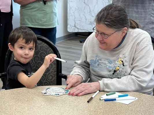 A child and a resident engaging in a craft activity