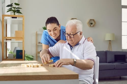 Staff and resident engaging in a game indoors
