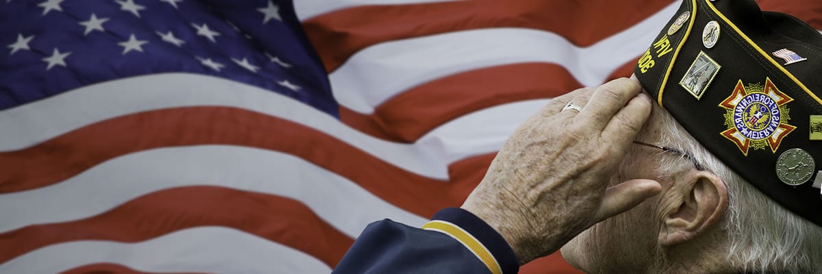 A veteran saluting in front of the American flag