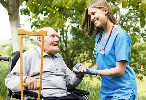 A nurse interacting with an elderly patient outside