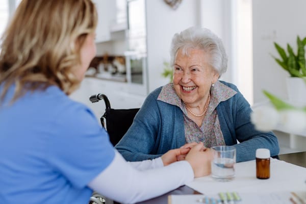 A caregiver and a resident enjoying a happy conversation