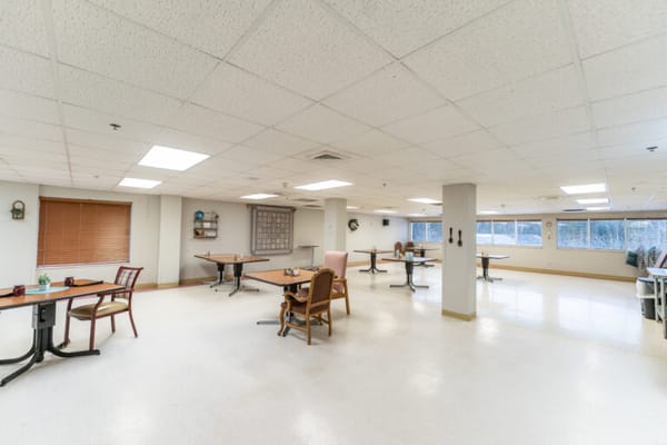 Bright common area with tables and chairs for activities