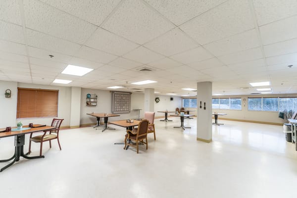 Bright common area with tables and chairs for activities