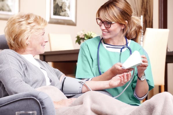 Nurse assisting a resident with a blood pressure monitor