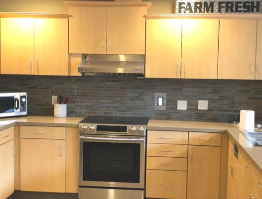 Modern kitchen area with wooden cabinets and appliances