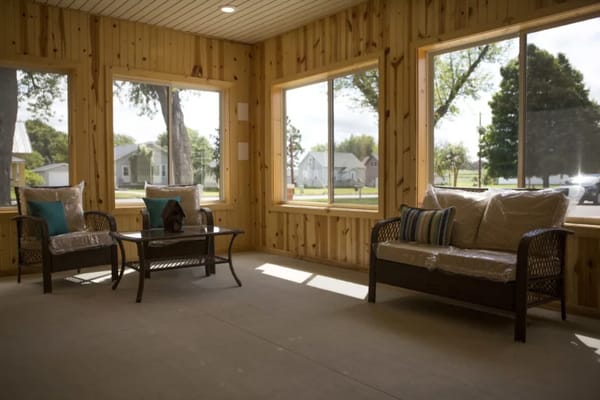 Bright sunroom with comfortable seating and large windows