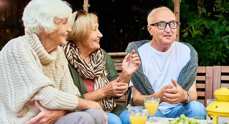 Seniors enjoying conversation outdoors with drinks
