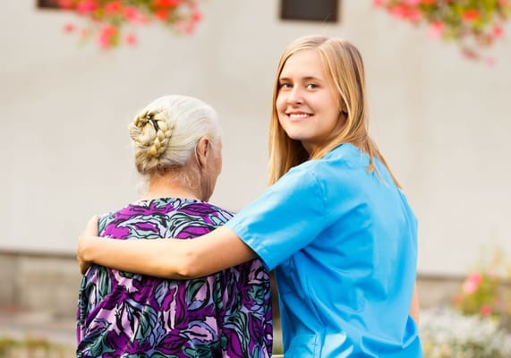 Caregiver smiling with a resident outdoors