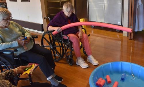 Residents participating in a fishing activity in the activity room