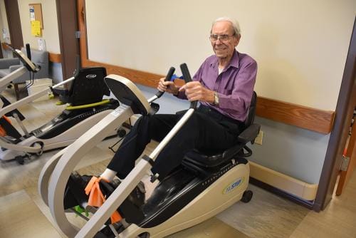 Senior resident exercising on an exercise machine