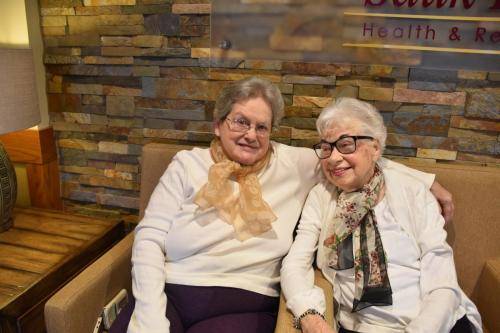 Two residents smiling together in a cozy lounge area
