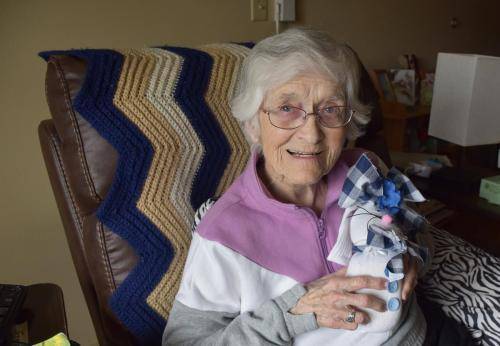 Elderly woman smiling with a gift in her hand
