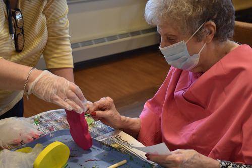 Resident engaged in a creative activity with assistance
