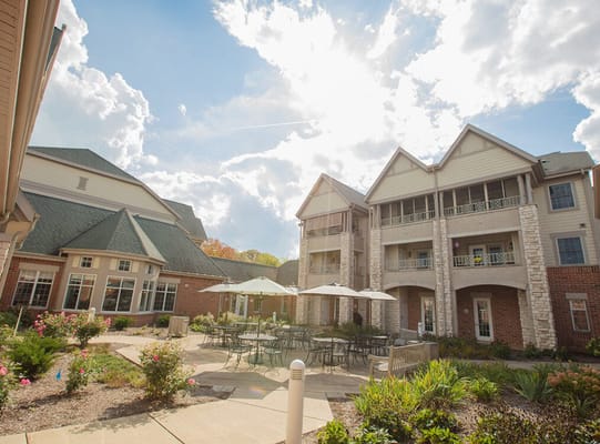 Exterior view of a senior living facility with terrace seating