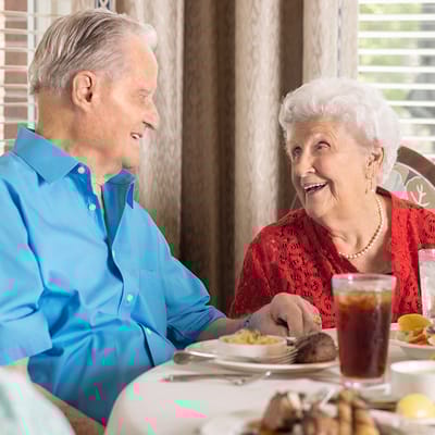 Elderly couple enjoying a meal together in a dining room
