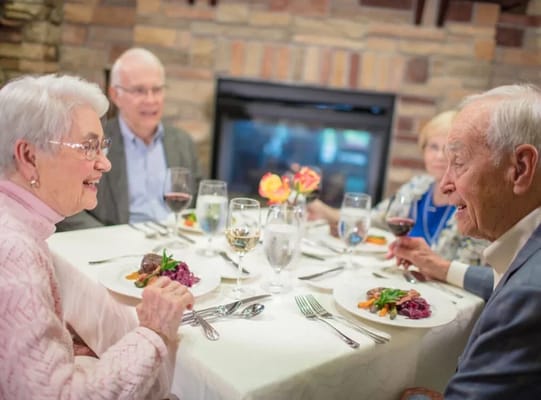 Residents enjoying dinner together in a dining room.