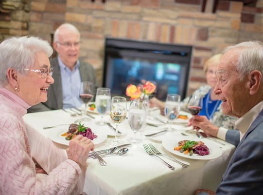 Residents enjoying dinner together in a dining room.