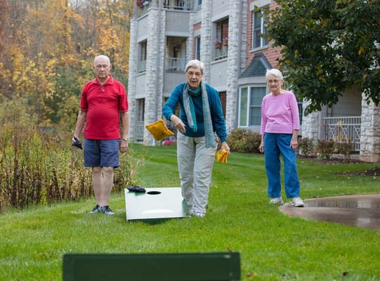Residents playing outdoor cornhole near the facility