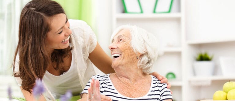 A caregiver and resident sharing a joyful moment