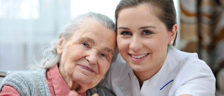 Caregiver hugging a senior resident in a warm environment
