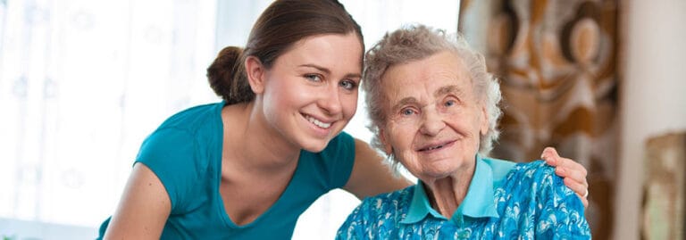 A caregiver smiling with an elderly resident