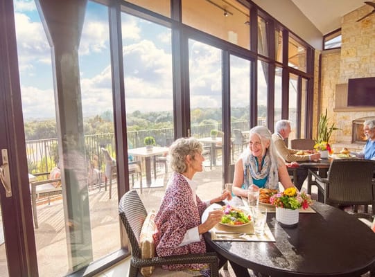 Two seniors enjoying a meal in a sunlit dining area