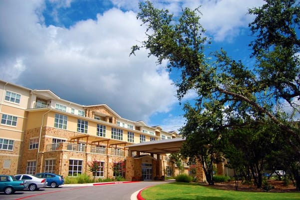 Exterior view of a senior living facility surrounded by trees