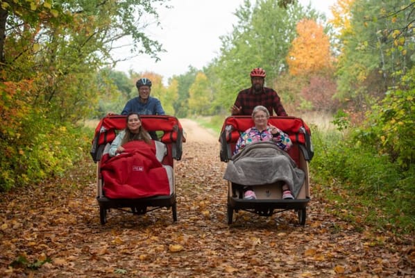 Residents enjoying a scenic outdoor pathway in wheelchairs