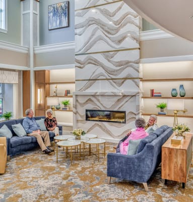 Residents socializing in a cozy common area with a fireplace