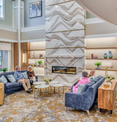 Residents socializing in a cozy common area with a fireplace