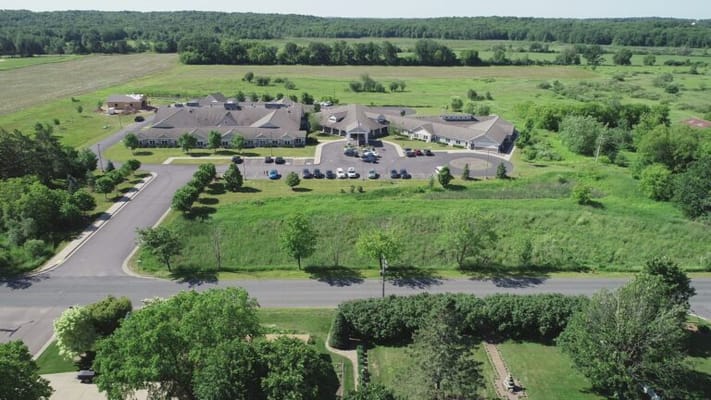 Aerial view of a senior living facility surrounded by green spaces