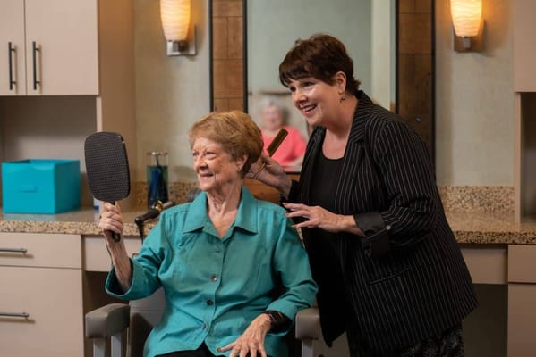Resident enjoying a hair salon experience with a staff member