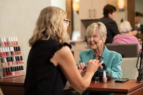 Residents enjoying manicure services in a common area