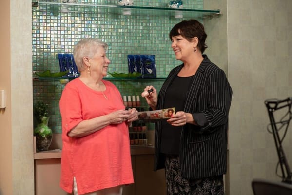 Two women chatting in a bright facility room