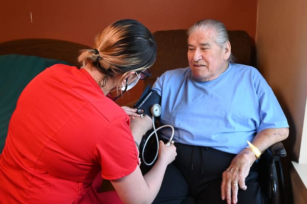 Healthcare staff taking a resident's blood pressure