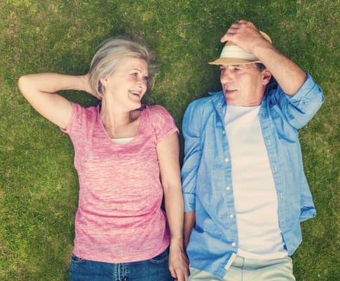 Two seniors enjoying time outdoors on the grass